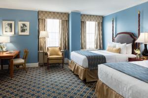 um quarto de hotel com duas camas e uma secretária em Francis Marion Hotel em Charleston