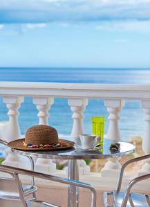 a hat on a table on a balcony with the beach at Villa Apollon in Sfakaki