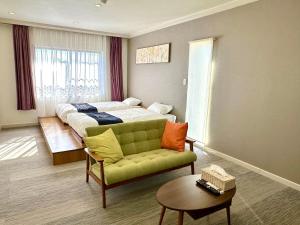 a bedroom with a bed and a couch and a table at 伊東山荘-Toki- in Ito