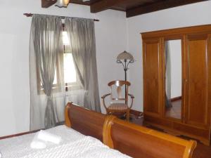a bedroom with a bed and a chair and a window at Hotel Kriváň in Kysucké Nové Mesto