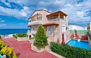 a villa with a swimming pool and the ocean at Villa Apollon in Sfakaki