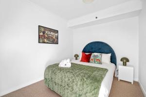 a bedroom with a bed with a green blanket at Central Chic Stay in Perth