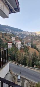 uma vista de uma estrada com prédios em uma colina em Hotel White Villa em Shimla