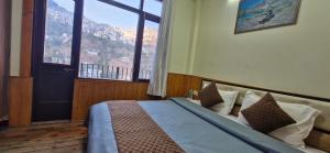 um quarto com uma cama com uma janela grande em Hotel White Villa em Shimla
