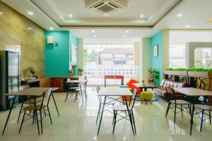 um restaurante com mesas e cadeiras e paredes azuis em Sans Hotel Nagari Malioboro em Yogyakarta