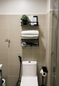a bathroom with a toilet and towels on a wall at 10mins to MOA Japan Aesthetic with Balcony Karaoke Kitchen 3mins to PICC in Manila