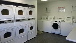eine Waschküche mit weißen Waschmaschinen und Waschmaschinen in der Unterkunft InTown Suites Extended Stay San Antonio TX - Airport in San Antonio
