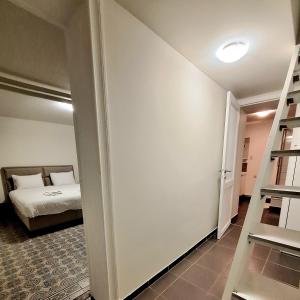 ein Schlafzimmer mit einem Bett und einer Leiter in einem Zimmer in der Unterkunft Le Duplex-suite Joséphine in Brüssel