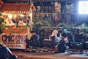 a group of people sitting in chairs in front of a bar at Years 1981 in Bangkok
