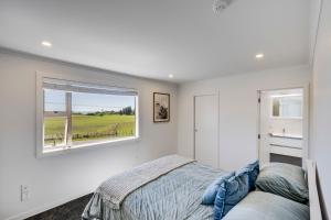 WaimaramaにあるAroha At 2252 - Waimarama Holiday Homeのベッドと窓のある寝室