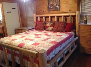 a bedroom with a wooden bed in a log cabin at Bears Lair cabin Chalet in Sevierville +38 photos