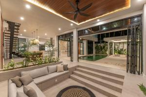 a living room with a couch and a ceiling fan at Luxury Ocean Dream Villa in Uluwatu