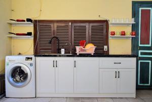 a kitchen with a sink and a washing machine at LushStay Abode - Hanoi Train Street in Hanoi