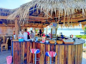 Sirindhornอินทนนท์แคมป์ปิ้ง เขื่อนสิรินธร的一个带椅子和草伞的酒吧