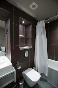 a bathroom with a toilet and a sink and a mirror at Jolly's Hotel Wetherspoon in Dundee