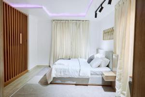 Un dormitorio blanco con una cama y una ventana. en MAHOGANY STUDIO at Cedar Loft, en Ikoyi