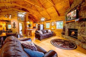 een woonkamer met een bank en een open haard bij Hunter Jack's Cabin in Sevierville