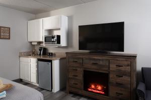 a living room with a fireplace and a television on a dresser at Harbor Shores on Lake Geneva in Lake Geneva