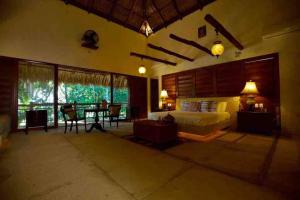 a bedroom with a bed and a table and chairs at Casa Los Cocoteros in Gallinero