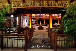 a restaurant with a large wooden pavilion with plants at Casa Los Cocoteros in Gallinero