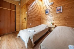 a bedroom with two beds in a wooden cabin at MAX Apartamenty - Pokoje - Domki - Restauracja - Basen in Mielno +254 photos