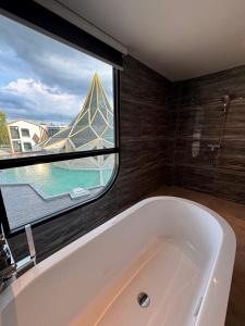 大城S3 Ayutthaya Hotel的带大窗户的浴室里的浴缸