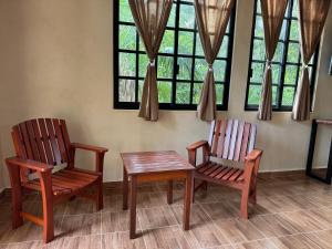 2 chaises et une table dans une chambre avec fenêtres dans l'établissement Casa Jardin del Amor, à Tulum