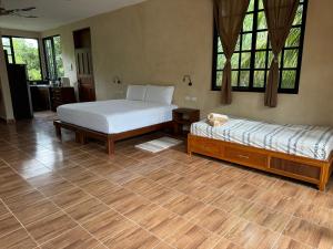 - 2 lits dans une chambre dotée de parquet et de fenêtres dans l'établissement Casa Jardin del Amor, à Tulum