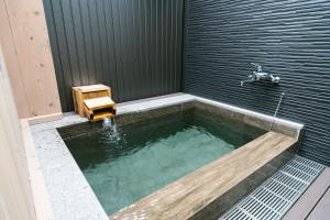 a bath tub with a bench sitting in it at グランステイ湯布院 GranStay YUFUIN in Yufu