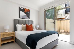 ein Schlafzimmer mit einem großen Bett und einem großen Fenster in der Unterkunft Urban Rest Bondi Beach in Sydney