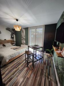 a bedroom with a bed and a table in it at Apartamento no Histórico Noyon in Noyon