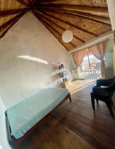 a bedroom with a bed and a chair in a room at Bungalows frente al mar en playa Wakama in San Vicente de Cañete +4 photos