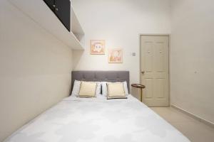 a bedroom with a white bed with two pillows at Retro Homestay Ipoh - Semi D 15pax Wedding in Ipoh