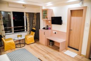 a small room with a small table and yellow chairs at Grand Resort in Puri