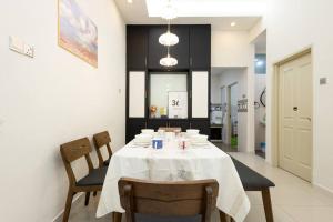 a dining room with a white table and chairs at Retro Homestay Ipoh - Semi D 15pax Wedding in Ipoh