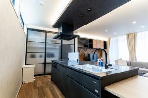 a kitchen with a black island in a room at みらいステイKAWACHI サウナspaや温泉付き-絶景オーシャンビューを満喫 in Kumamoto