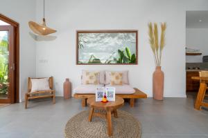 een woonkamer met een bank en een tafel bij Villa Lounes 1 - Walking Distance to Nyanyi Beach in Tanah Lot