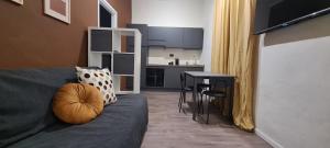 a living room with a couch and a kitchen at Maison Boutique in Ivrea