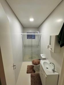ein Badezimmer mit Dusche, Toilette und Waschbecken in der Unterkunft Casa em imbe in Imbé