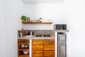 een keuken met een aanrecht met een fornuis en een koelkast bij Villa Lounes 1 - Walking Distance to Nyanyi Beach in Tanah Lot