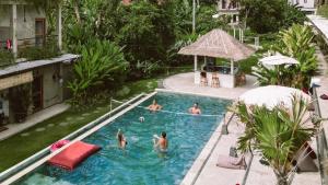 a group of people in a swimming pool at Sepeda Hostel in Canggu