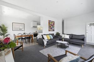 a living room with a couch and a table at Rye Beach Retreat - newly renovated with private garden and alfresco dining in Rye