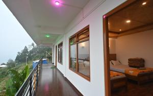 a room with a balcony with a bed and a window at The Cherry Blossom Homestay By StayApart in Takdāh