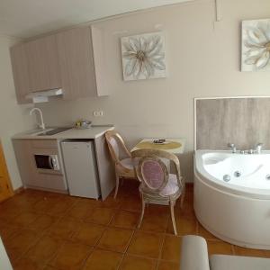 a kitchen with a sink and a tub and a table at Biosfera Suites in Palomera