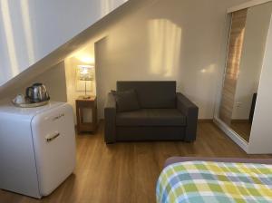 a living room with a chair and a refrigerator at Altstadthotel Marktheidenfeld in Marktheidenfeld