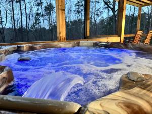 a jacuzzi tub with blue water in it at A Great Escape in Ellijay