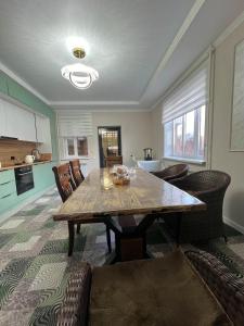 a living room with a wooden table and chairs at MARAL GuestHouse in Karakol +21 photos