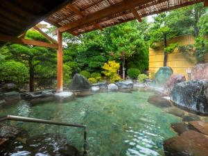 a pool of water with rocks in a garden at Hotel Sunvalley Izunagaoka Main Building in Izunokuni