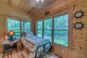 ein Schlafzimmer in einem Blockhaus mit einem Bett und Uhren in der Unterkunft A River Runs Through It in Cherry Log