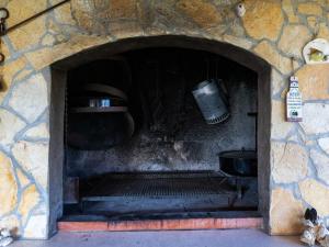 a stone fireplace with a stove in a stone wall at Apartments Belenum - Comfort Double Room with Balcony and Sea View no 1 in Mlini